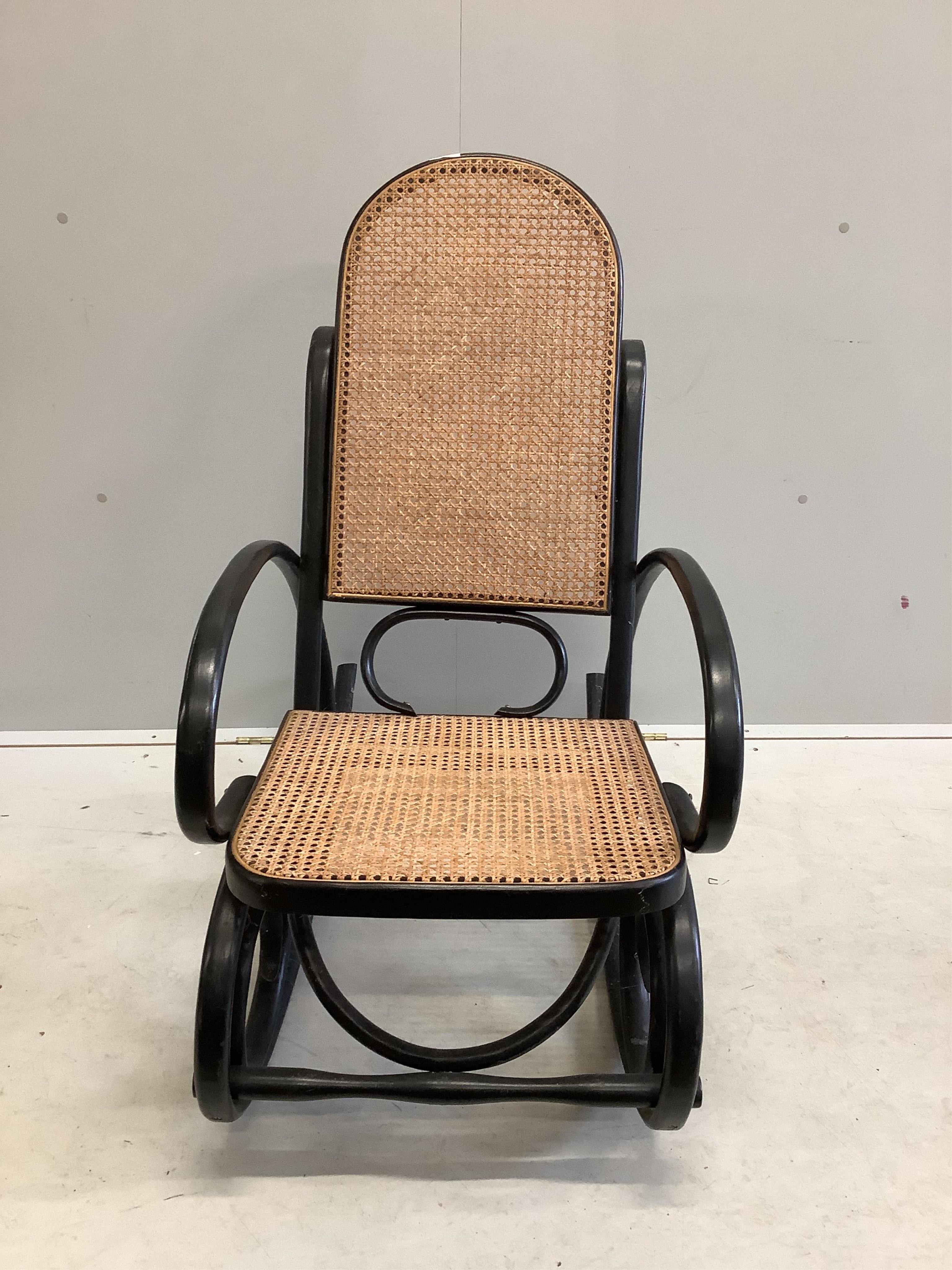 An early 20th century ebonised caned bentwood rocking chair, possibly Thonet, width 53cm, depth 100cm, height 100cm. Condition - fair to good